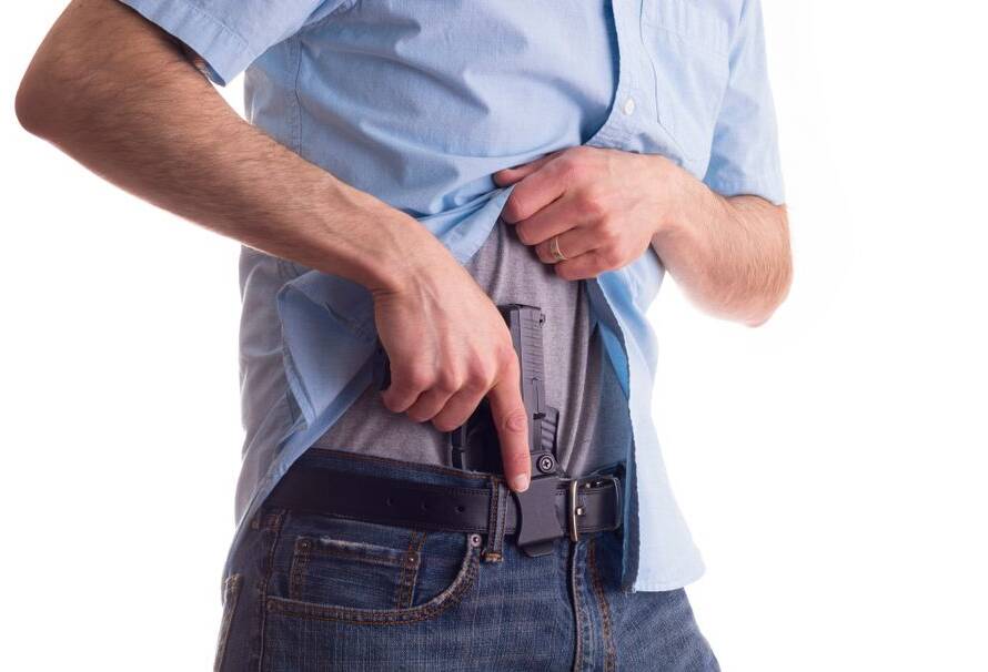 Man holding a holster in appendix carry Position